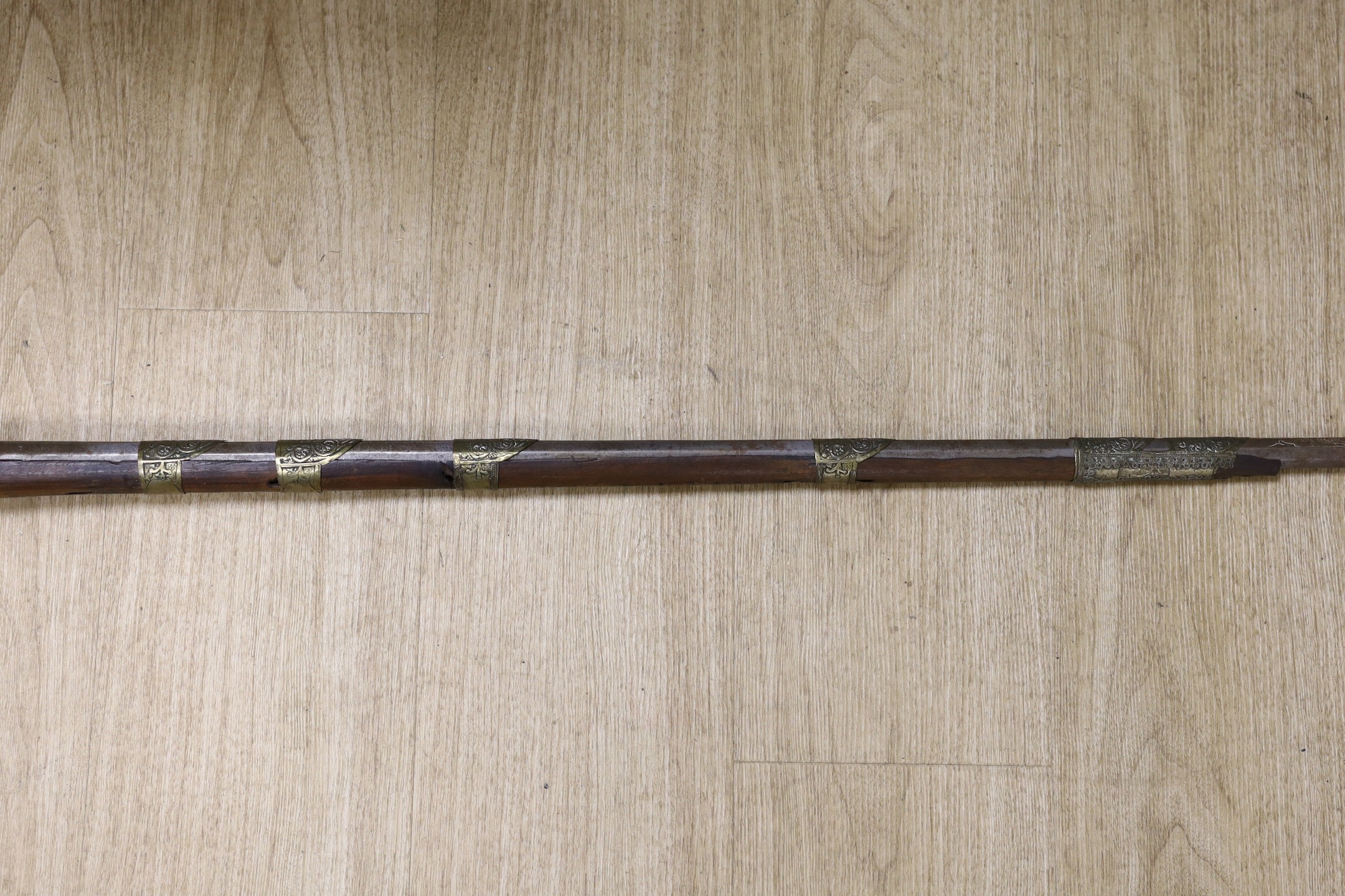 An Eastern decoratively metal mounted antique musket, 132cms long.